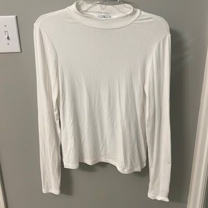 White mock-neck long sleeve top.